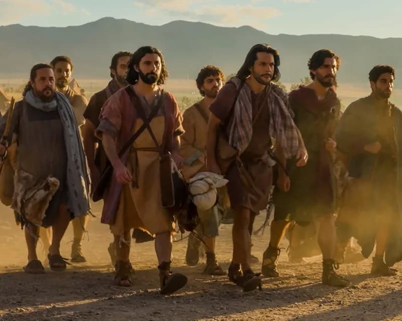 Jesus and the disciples walking together along a dusty road at golden hour, dust rising behind them